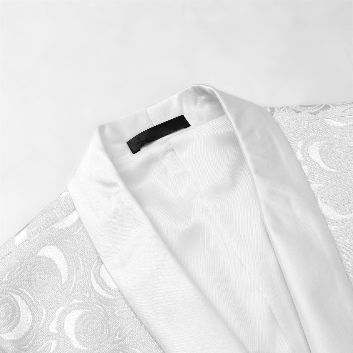White # Men's slim fit 2-piece paisley suit with satin peaked lapel and single-breasted button closure, white patterned formal blazer jacket with center vent and fully lined interior, matching flat-front trousers, elegant polyester viscose blend suit for wedding, prom, party and formal occasions, isolated on white background.